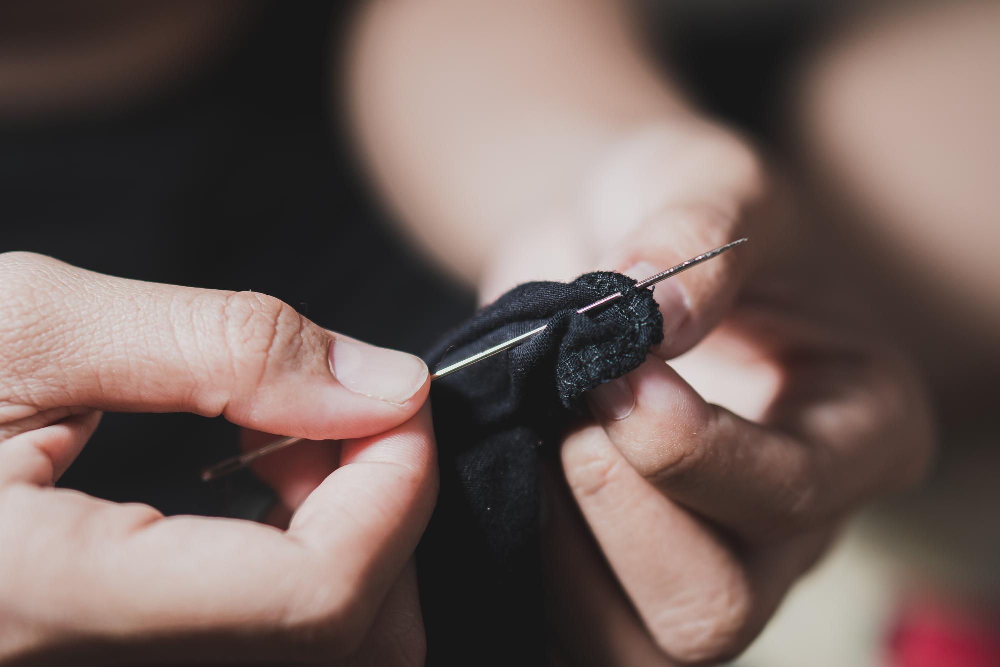 Craftsman hands embroidering a pattern